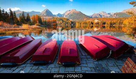 Barche rosse sul molo. Colorata scena autunnale del lago di Strbske pleso. Vista panoramica mattutina del Parco Nazionale degli alti Tatra, Slovacchia, Europa. Bellezza di n Foto Stock