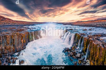 Vista dal drone volante della cascata Selfoss. Un'estate incredibile alba sul fiume Jokulsa a Fjollum, il Parco Nazionale Jokulsargljufur. Colorata scena mattutina Foto Stock