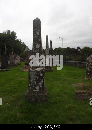 Una fila di monumenti commemorativi a forma di obelisco nei terreni della chiesa di Monigaff (Minnigaff) o Kirk , vicino a Newton Stewart, Dumfries e Galloway. La 'nuova' chiesa è una chiesa di B listed costruita nel 1836 su un disegno gotico di Revival da William Burn. All'interno dello stesso terreno si trovano i resti della vecchia chiesa con relative sepolture segnate con antiche lapidi. E 'costruito sul sito di un vecchio castello motte e bailey Foto Stock