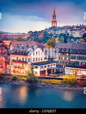 Emozionante paesaggio urbano serale della città di Berna con la cattedrale di Berna sullo sfondo. Spettacolare tramonto autunnale sulla Svizzera, sul fiume Aare, in Europa. In viaggio Foto Stock