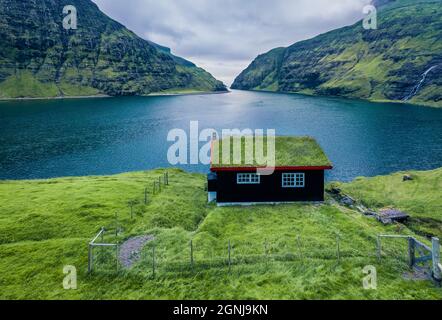 Splendida vista estiva del villaggio di Saksun con tradizionale casa sul tetto di tappeti erbosi. Meravigliosa scena mattutina di Pollurin Laguna, Isole Faroe, Danimarca, Europa. TR Foto Stock