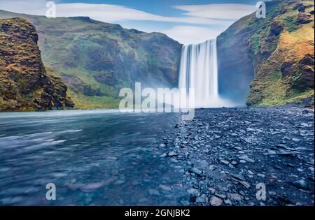 Vista mistica mattutina della cascata di Skogafoss. Splendido paesaggio estivo del fiume Skoga. Pittoresca scena all'aperto dell'Islanda, in Europa. Bellezza della natura Foto Stock