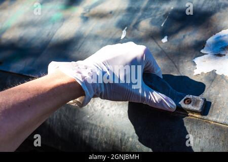 Mano umana in guanto medico bianco che apre un cestino di rifiuti. Covid e altre malattie di protezione. Igiene nel riciclaggio dei rifiuti. Nuove regole per l'autosicurezza Foto Stock