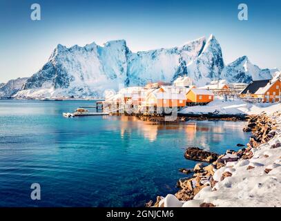 Scena mattutina di sole di popolare destinazione turistica - arcipelago Lofoten Islands. Case colorate sulla riva del mare norvegese. Luminosa vista invernale di Foto Stock