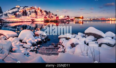 Incredibile paesaggio urbano invernale della città di Reine, Norvegia, Europa. Scena calmo serale delle isole Lofoten. Grande tramonto sul mare norvegese. Vita sul circo polare Foto Stock