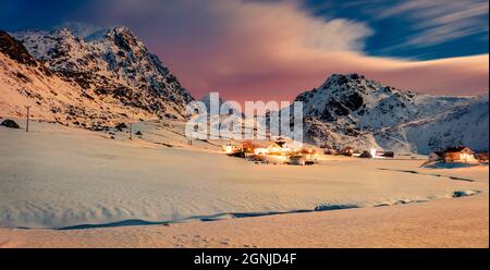 Incredibile scena invernale sulle isole Lofoten. Colorata vista notturna del villaggio di Utakleiv, Norvegia, Europa. Incredibile luna illuminato valle nevosa Foto Stock