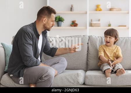 Violenza domestica e abuso dei bambini. Furioso papà arrabbiato gridando al figlio piccolo, gridando ragazzo sensazione offeso Foto Stock