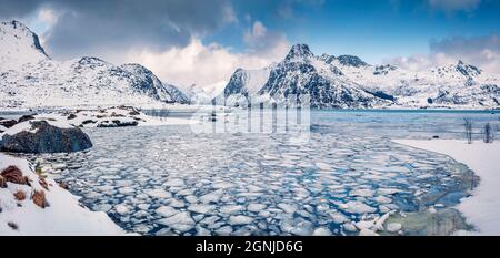 Incredibile scena invernale su cerchio polare. Fiordo Booken congelato sull'isola di Flakstadoya. Vista panoramica mattutina delle isole Lofoten con Hustinden mountai Foto Stock