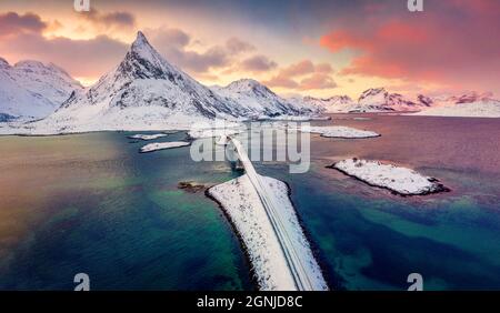 Vista dal drone volante delle isole Lofoten. Sorprendente alba invernale in Norvegia, Europa. Vista aerea mattutina del ponte Fredvang con picco Volandstind Foto Stock