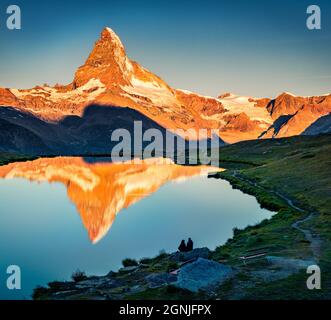 Turisti che ammirano la bella vista del lago di Stellisee. Splendida scena serale del Cervino (Monte Cervino, Monte Cervin) nelle Alpi svizzere, in Svizzera, in Europa. B Foto Stock