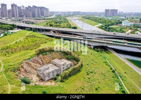 Zhengzhou, Zhengzhou, Cina. 26 settembre 2021. Il 23 settembre 2021, Zhengzhou, Henan, la ''Villa Nail Household' situata in fondo alla fossa nella cintura verde della terza circonvallazione occidentale. Dopo una pioggia pesante, il suolo intorno alla buca crollò. Quasi tutto il primo piano della casa è stato sommerso da limo ed è stato chiamato dai passanti-da ''la famiglia più miserabile del chiodo.'.questa casa è due edifici alti tre piani. È stato circondato da terra e bambù dal 2015. Il proprietario, il signor Zheng, ha detto che la gente ha vissuto qui per generazioni. Non c'è elettricità o acqua, e. Foto Stock