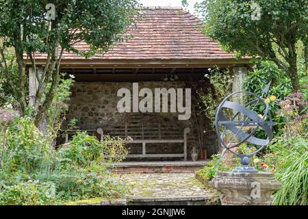 Un rifugio che fornisce un luogo di riposo all'interno di un vecchio giardino inglese Foto Stock