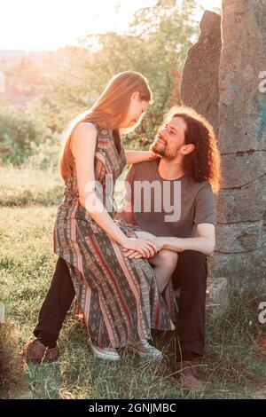 Hipster, coppia romantica divertirsi nel parco. Godendo il sole di pomeriggio. Ragazzo capelli ricci con ragazza dai capelli lunghi. Foto Stock