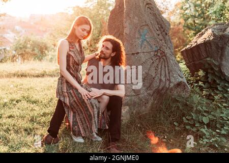 Hipster, coppia romantica divertirsi nel parco. Godendo il sole di pomeriggio. Ragazzo capelli ricci con ragazza dai capelli lunghi. Foto Stock