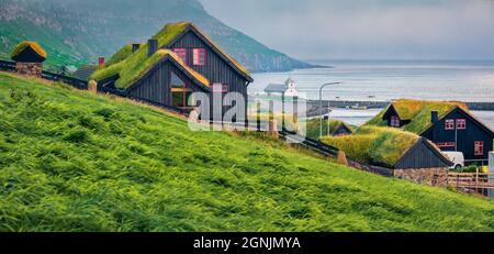 Spettacolare vista estiva del villaggio di Kirkjubour con case sul tappeto erboso, Isole Faroe, Danimarca, Europa. Bella scena mattutina di Hestur Island. In viaggio Foto Stock