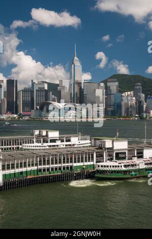 Un traghetto Star arriva al molo di Tsim Sha Tsui a Kowloon, con WAN Chai, Hong Kong Island, visibile attraverso Victoria Harbour Foto Stock