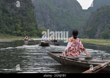 Donna vietnamita seduta e godersi il tour in barca a Tam Coc, Ninh Binh, Vietnam Foto Stock