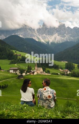 Paese di Santa Magdalena in Val di Funes sulle Dolomiti. Vista autunnale della valle con alberi colorati e Odle gruppo di montagna. Italia, uomo e donna in vacanza, escursioni in montagna Foto Stock