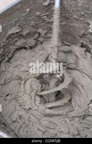 Miscelazione di una soluzione di gesso con un trapano elettrico. Miscelazione dell'adesivo. Ristrutturazione della casa. Foto Stock