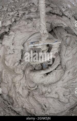 Miscelazione di una soluzione di gesso con un trapano elettrico. Miscelazione dell'adesivo. Ristrutturazione della casa. Foto Stock