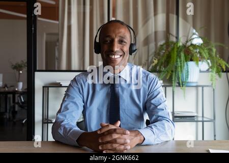 Felice uomo d'affari afroamericano maturo in cuffia sorridente alla webcam Foto Stock