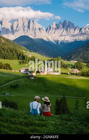 Paese di Santa Magdalena in Val di Funes sulle Dolomiti. Vista autunnale della valle con alberi colorati e Odle gruppo di montagna. Italia, uomo e donna in vacanza, escursioni in montagna Foto Stock