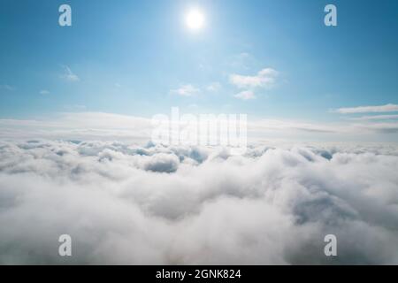 Scatto aereo di nuvole bianche e soffici e un po' di cielo blu in lontananza mentre vola sopra le nuvole. Sfondo dell'antenna. Belle nuvole di cumulo captur Foto Stock