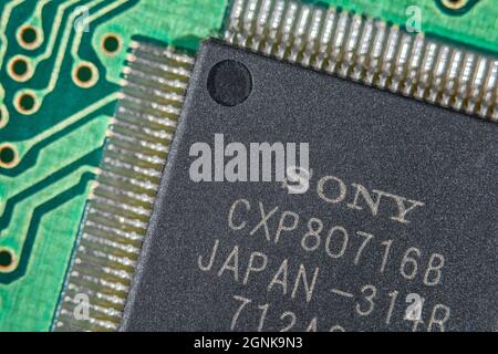 Piedini o piedini ad ala di gabbiano di un circuito integrato/semiconduttore IC Sony su una scheda a circuito stampato verde. Per la tecnologia elettronica, la carenza di chip a livello mondiale Foto Stock