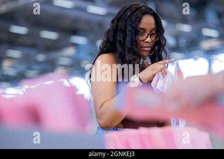 Colonia, Germania. 26 settembre 2021. Un lavoratore elettorale che conta le schede assentee per l'elezione del Bundestag nella sala espositiva 6. Credit: Rolf Vennenbernd/dpa/Alamy Live News Foto Stock