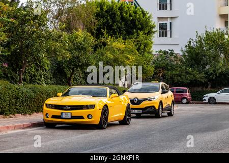 Kemer, Turchia - 08,31, 2021: Giallo brillante Chevrolet Camaro con strisce nere in piedi al parcheggio auto vicino hotel di lusso sotto il sole luminoso. Foto Stock