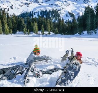 Coppia felice che gioca nella neve durante il tour con racchette da neve Foto Stock