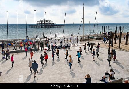 Brighton UK 26 settembre 2021 - Un gruppo di ballerini si godono sul lungomare di Brighton in un pomeriggio caldo ma blustery lungo la costa meridionale : Credit Simon Dack / Alamy Live News Foto Stock