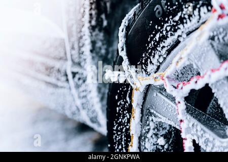 Pneumatico auto con catene da neve su giorno d'inverno nevoso Foto Stock