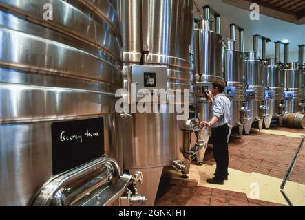 SERBATOI DI MATURAZIONE CANTINA, moderna cantina francese di Borgogna, con l'operatore che imposta i controlli computer su un serbatoio di fermentazione nella cuverie della cantina la Sablière di Louis Jadot, Beaune, Côte d'Or, Francia. Foto Stock