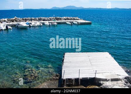 Corfù isola Grecia Nissaki villaggio Pretty piccolo porto con barche ormeggiate aspetto paesaggio vista del mare e del cielo spazio copia Foto Stock
