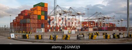 Southampton, Inghilterra, Regno Unito. 2021. Contenitori di spedizione impilati in alto in un'apertura per container svanita da gru a portale in banchina. REGNO UNITO Foto Stock