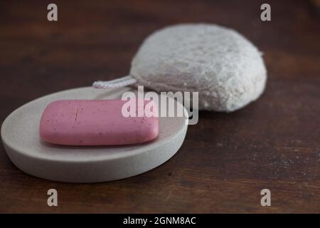 foto primo piano di una saponetta rosa e una spugna da bagno Foto Stock