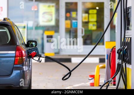 auto blu rifornimento presso la stazione di benzina il giorno d'estate, primo piano Foto Stock