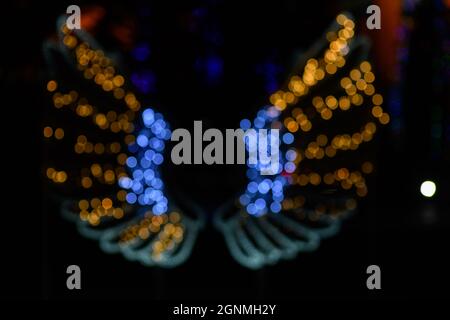 Una farfalla formata dalle luci LED e il bokeh effetto in vari colori. Foto Stock