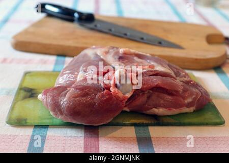 Coscia di tacchino grezza su tagliere di vetro Foto Stock