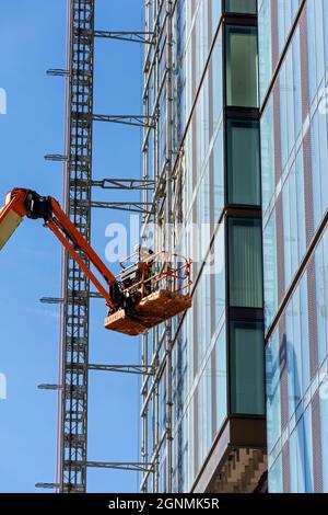 Piattaforma di accesso che lavora al blocco di appartamenti Elizabeth Tower in costruzione Settembre 2021, Crown Street, Manchester, Inghilterra, Regno Unito Foto Stock