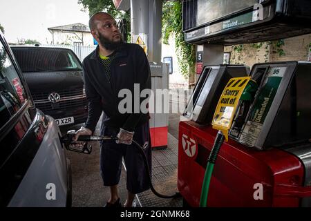 Il conducente della cabina è il serbatoio di riempimento accanto al segnale di fuori uso sulle pompe di benzina senza carburante presso la stazione di servizio a Londra, Regno Unito Foto Stock