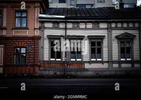I dettagli architettonici di una tradizionale casa in legno accanto ad una casa in mattoni a Turku, Finlandia Foto Stock