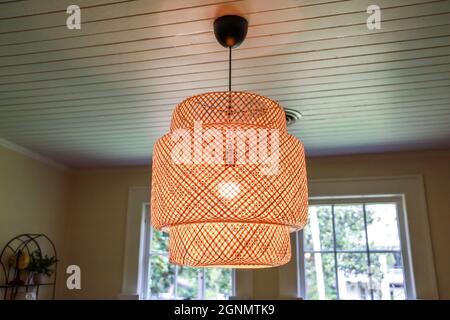 Una piccola sala da pranzo con un'illuminazione in rattan di tendenza Foto Stock