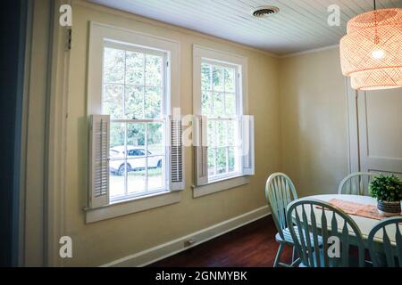 Una piccola sala da pranzo con un'illuminazione in rattan di tendenza Foto Stock