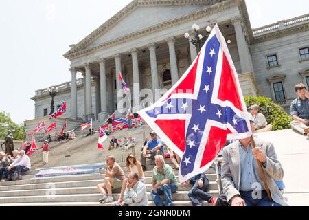 I sostenitori confederati si riuniscono sui gradini della costruzione della capitale del South Carolina, sventolando bandiere ribelli per celebrare il Confederate Memorial Day 7 maggio 2016 a Columbia, South Carolina. Gli eventi che segnano il patrimonio confederato meridionale giungono quasi un anno dopo la rimozione della bandiera confederata dal campidoglio a seguito dell'assassinio di nove persone nella storica chiesa nera di Madre Emanuel AME. Foto Stock