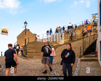 Villeggianti in fondo ai famosi 199 passi dalla città che conduce alla chiesa di St Marys e all'Abbey Whitby North Yorkshire UK Foto Stock