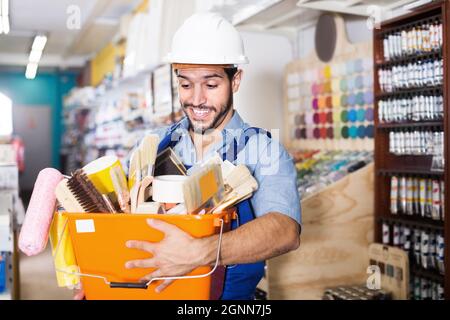 Uomo padrone in cesto porta casco con attrezzi Foto Stock