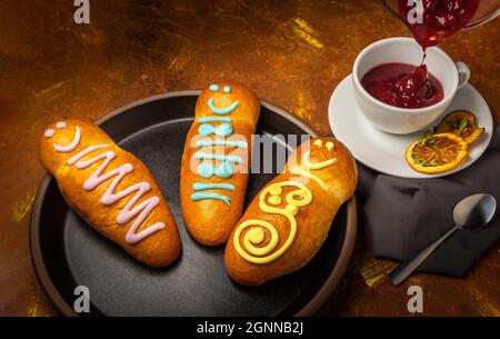 caraffa con colada viola in una tazza bianca accanto a tre guaguas de pan Foto Stock