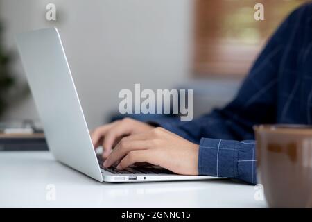 Mano di uomo d'affari che lavora da casa usando il computer portatile a Internet on-line sulla scrivania, stile di vita di nuovo normale, distanza sociale, lavoro freelance dentro Foto Stock